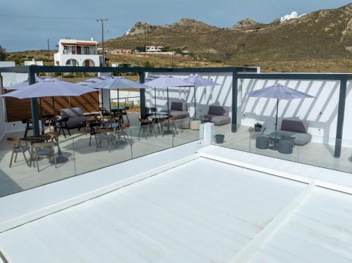 a balcony with tables and chairs and umbrellas at El Mar Naxos in Naxos Chora