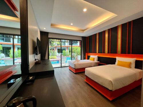 a bedroom with two beds and a television in it at WOW PHUKET in Phuket Town