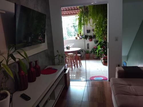 a living room with a couch and a table with plants at Casa da Marcinha in Sao Paulo
