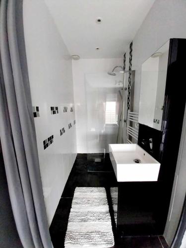 une salle de bain blanche avec un lavabo et un miroir dans l'établissement La chapusine, à Bourcefranc