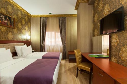 a hotel room with two beds and a desk at Alrazi Hotel in Istanbul