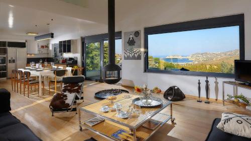 Una sala de estar con una mesa y una gran ventana. en Casa Blue Villa in Crete, en Agia Pelagia