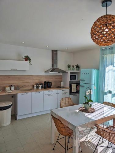 Il comprend une cuisine équipée d'une table et d'un réfrigérateur bleu. dans l'établissement L'instant sorgue, à LʼIsle-sur-la-Sorgue