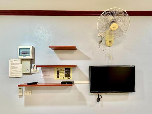 a television and a fan on a wall at โรงแรมกาญจนาสกลนคร in Sakon Nakhon