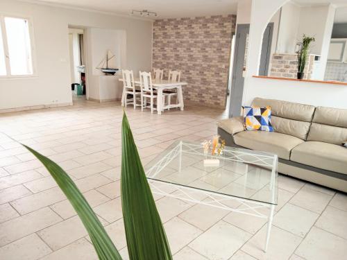 un salon avec un canapé et une table dans l'établissement Maison spacieuse proche de la Mer, à Échillais