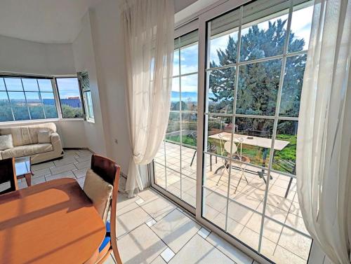 a living room with a table and a large window at Ecoscape Luxury Villa Lamia in Lamía