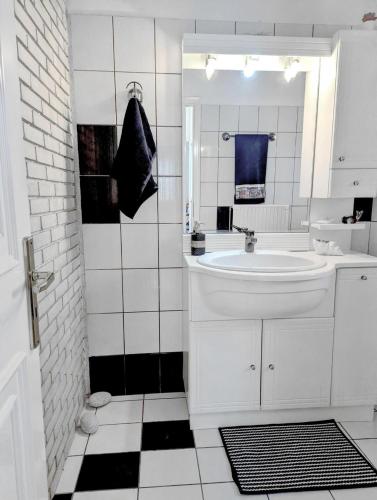 a white bathroom with a sink and a mirror at Ecoscape Luxury Villa Lamia in Lamía