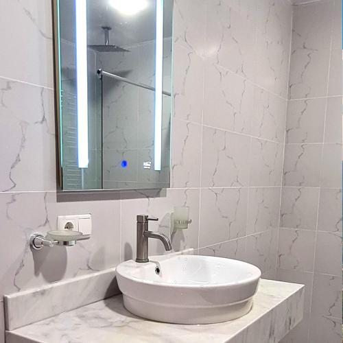 a white bathroom with a sink and a mirror at Seaside 2-Room 3-Balconies Apt#12 Stunning View in Batumi