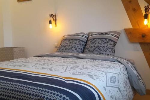 un lit avec des draps et des oreillers bleus et blancs dans l'établissement charmant studio idéalement situé, à Caen