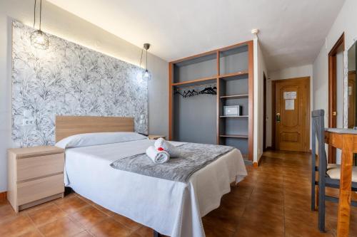 a bedroom with a white bed and a wall at Hotel Arillo in Noja