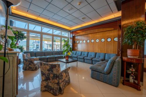 a lobby with blue couches and chairs in a building at Hotel Arillo in Noja