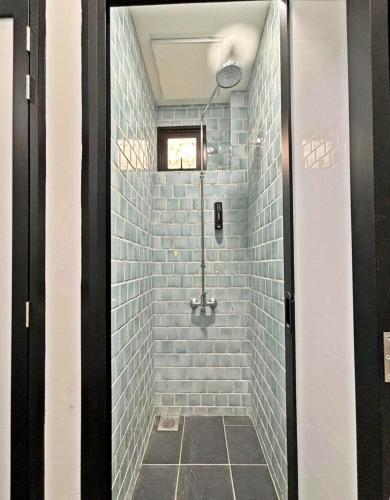 a bathroom with a shower with blue tiles at POTATO Boutique Hostel in Singapore