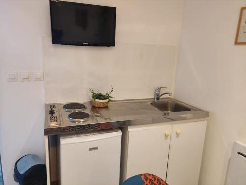 une petite cuisine avec un évier et une cuisinière dans l'établissement annonce désactiver, à Montbozon