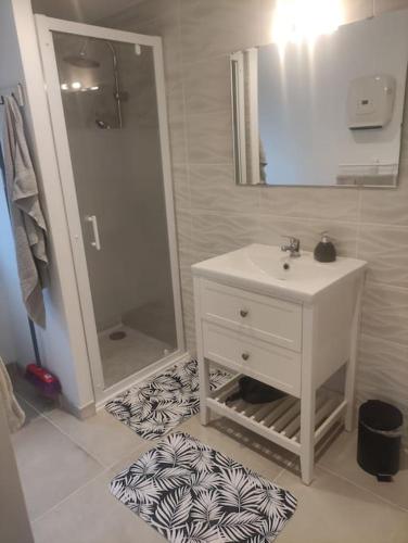 une salle de bain avec un lavabo blanc et un miroir dans l'établissement annonce désactiver, à Montbozon