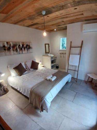 une chambre avec un grand lit avec un plafond en bois dans l'établissement Villa Taru Pinarello, à Mangialla