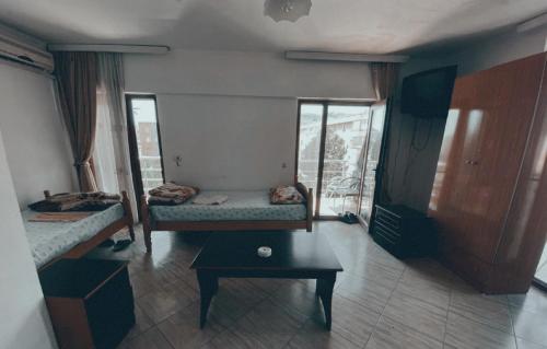 a room with two beds and a table in it at Bar Hotel Tirana in Kukës