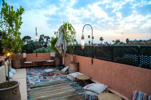 a patio with tables and chairs and an umbrella at Riad Anya & SPA in Marrakesh