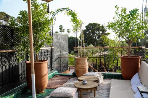 a patio with potted plants on a balcony at Riad Anya & SPA in Marrakech