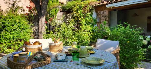 ClaviersにあるLa Belle Histoireの青いチェックのテーブルクロスとバスケットが置かれたテーブル