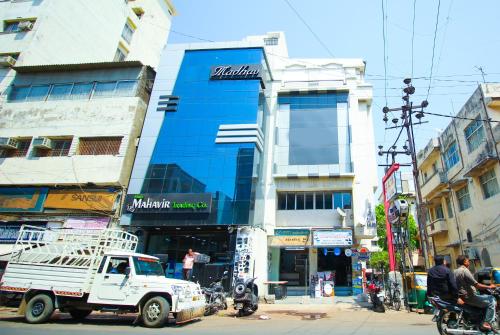 a white truck parked in front of a building at Hotel Upasana in Rajkot