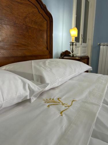 a white bed with white sheets and a wooden headboard at La Casa di Ilde Maison de charme et d art in Morcone