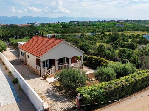 a small white house with a red roof at Kuća za odmor Pixie in Vrsi