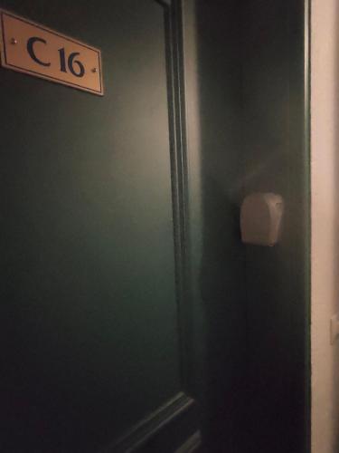 a bathroom with a green door with a sign on it at charmant appartement 2-4 personnes coeur de chamonix in Chamonix-Mont-Blanc