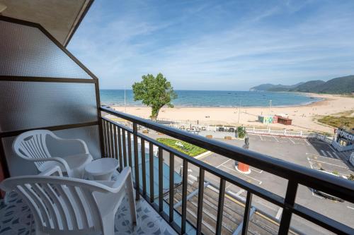 a balcony with a chair and a view of a beach at Hotel Arillo in Noja