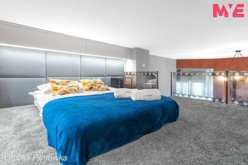 a large bedroom with a large bed with blue sheets at MYE Apartments - Kamienica Sienkiewicza in Łódź