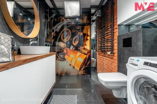 a bathroom with a washer and dryer in it at MYE Apartments - Kamienica Sienkiewicza in Łódź