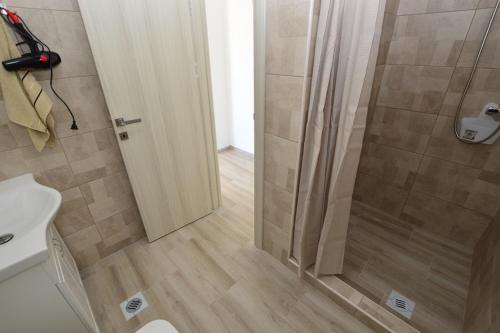 a shower with a glass door in a bathroom at Apartmani Tomic Igalo in Igalo