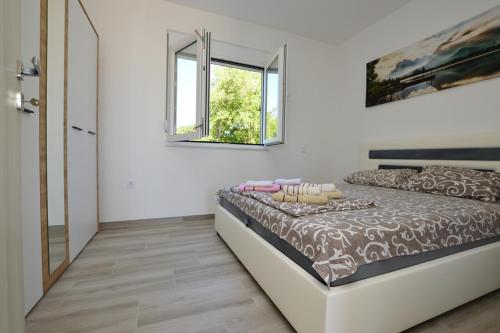 a bedroom with a bed and a window at Apartmani Tomic Igalo in Igalo
