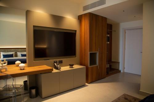 a living room with a large television on a wall at Abi's Hotel & SPA Vlore in Vlorë