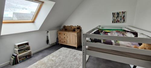 une chambre avec un lit superposé et une fenêtre dans l'établissement Maison de vacances à 5 min des plages, à Ploemeur