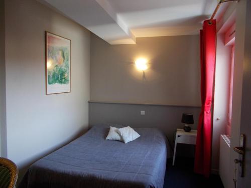 a bedroom with a blue bed and a red curtain at Hôtel Restaurant La Belle Epoque in Le Creusot