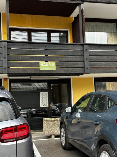 two cars parked in a parking lot in front of a building at Ferienwohnung AltePost in Bad Aussee