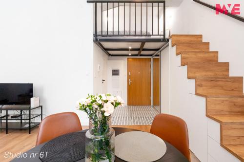 a dining room with a table with a vase of flowers at MYE Apartments - Kamienica Sienkiewicza in Łódź