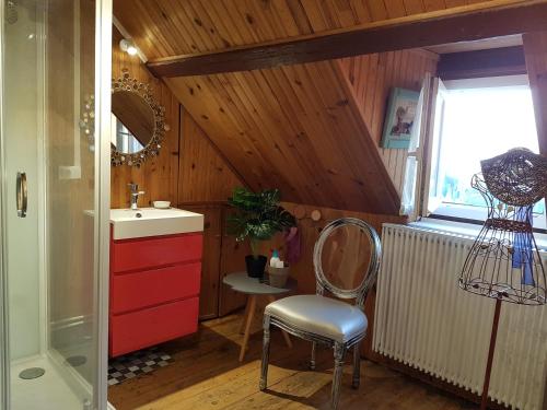 La salle de bains est pourvue d'un lavabo, d'une chaise et d'une fenêtre. dans l'établissement la maison de Domi, à Trouville-sur-Mer