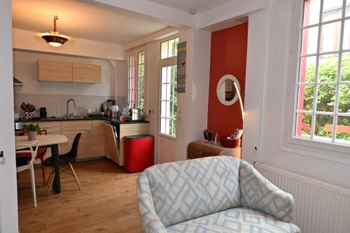 une cuisine avec une chaise et une table dans une pièce dans l'établissement la maison de Domi, à Trouville-sur-Mer