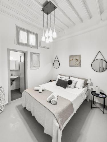 um quarto branco com uma cama grande e toalhas em MATEOS APARTMENT WINDMILLS TOWN em Míconos