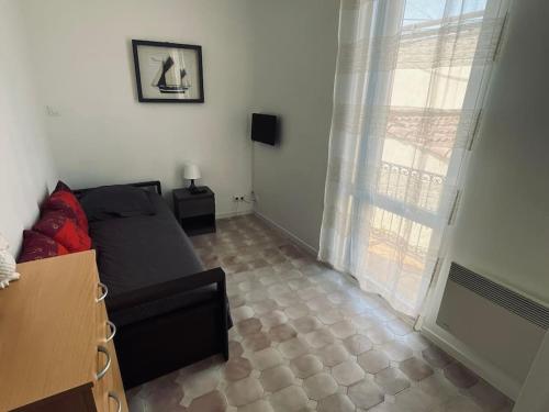 un salon avec un lit et une fenêtre dans l'établissement Petit coin de paradis au cœur de Marseille, à Marseille