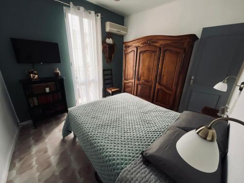 - une chambre avec un lit, une lampe et une télévision dans l'établissement Petit coin de paradis au cœur de Marseille, à Marseille