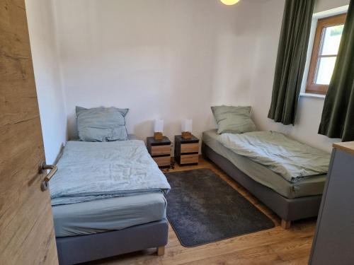 a bedroom with two beds and a window at Nicky apartments and studios in Niederau