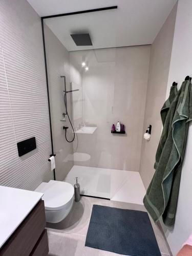 a white bathroom with a toilet and a shower at Casa Torwoods Las Colinas in Orihuela Costa