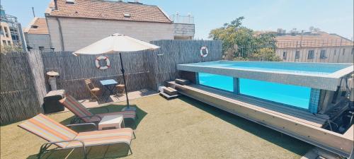 Meqor H̱ayyimにあるPrivate Swimming Pool ! דירת סטודיו קטנה עם בריכה פרטיתの椅子2脚と傘が備わったプール
