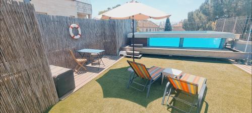 a backyard with a table and chairs and an umbrella at Private Swimming Pool ! דירת סטודיו קטנה עם בריכה פרטית in Meqor H̱ayyim