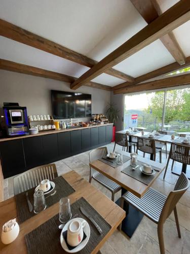 a restaurant with wooden tables and chairs and a counter at Hotel Clair de Lune in Zonza
