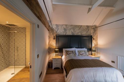 a bedroom with a large bed and a walk in shower at Home Farm House in Fakenham