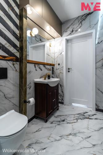 a bathroom with a toilet and a sink at MYE Apartments - Verona Włókiennicza in Łódź