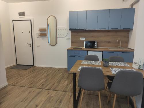 a kitchen with blue cabinets and a table and chairs at DelEric apartments in Eforie Nord